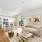 Modern apartment at The Beverly Collection with white cabinetry, stainless steel appliances, and sunlit living and dining space