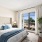 Primary bedroom at The Beverly Collection in Beverly MA featuring natural light, modern furniture, and views of the neighborhood