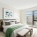 Bright bedroom at The Beverly Collection apartments in Beverly MA with chic furnishings, large window, and cozy bedding