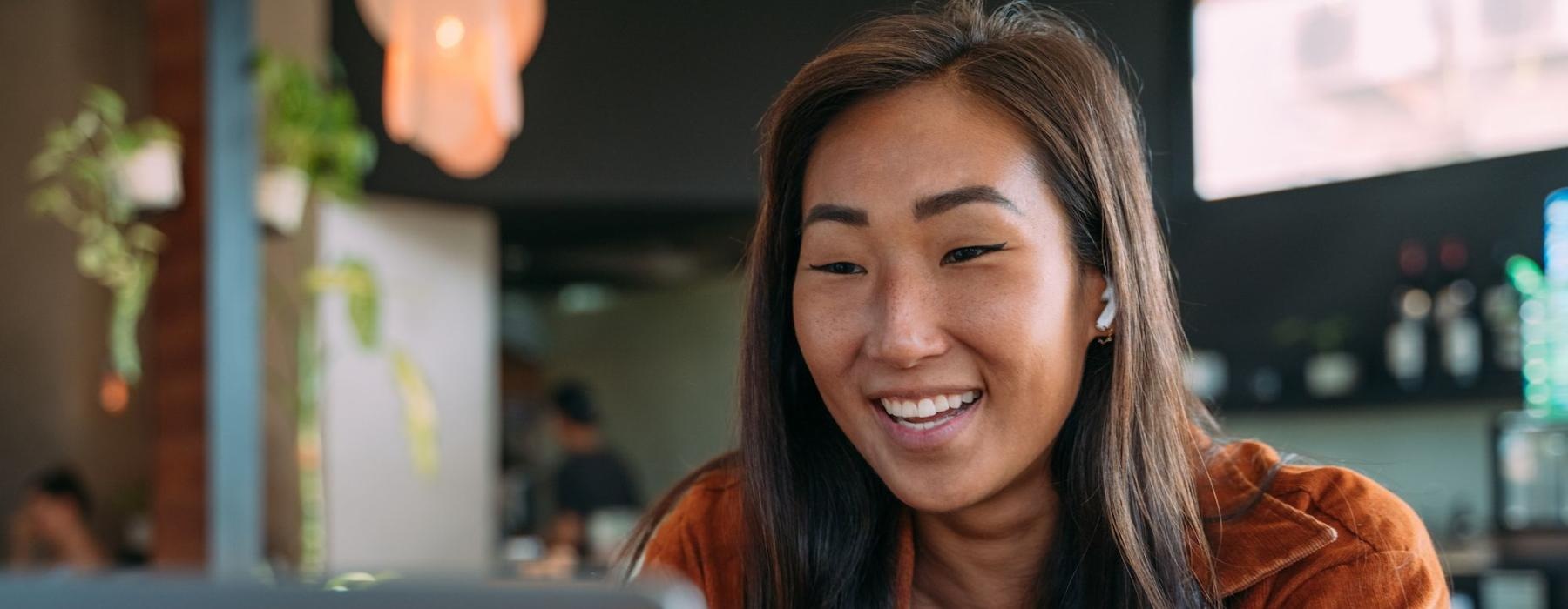 a woman smiling while working on laptop